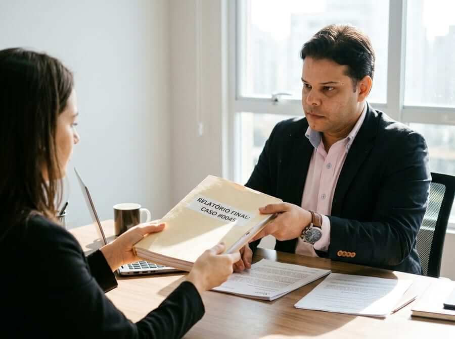 Sócio sênior entregando relatório de investigação ao cliente
